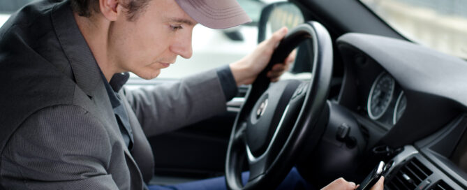 Distracted driver looking at his phone while driving